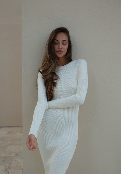 A milk-colored long-sleeved knit with a flattering regular fit, designed to accentuate your waist with a pencil-shaped skirt. Features include a round neck, fine ribbed design, and a neat midi length.