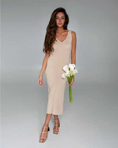 A cream-colored silhouette dress crafted from delicate natural cotton fabric, featuring a simple sheer fit with a sleeveless design and a plunging neckline. The dress exudes elegance and sophistication, perfect for various occasions.