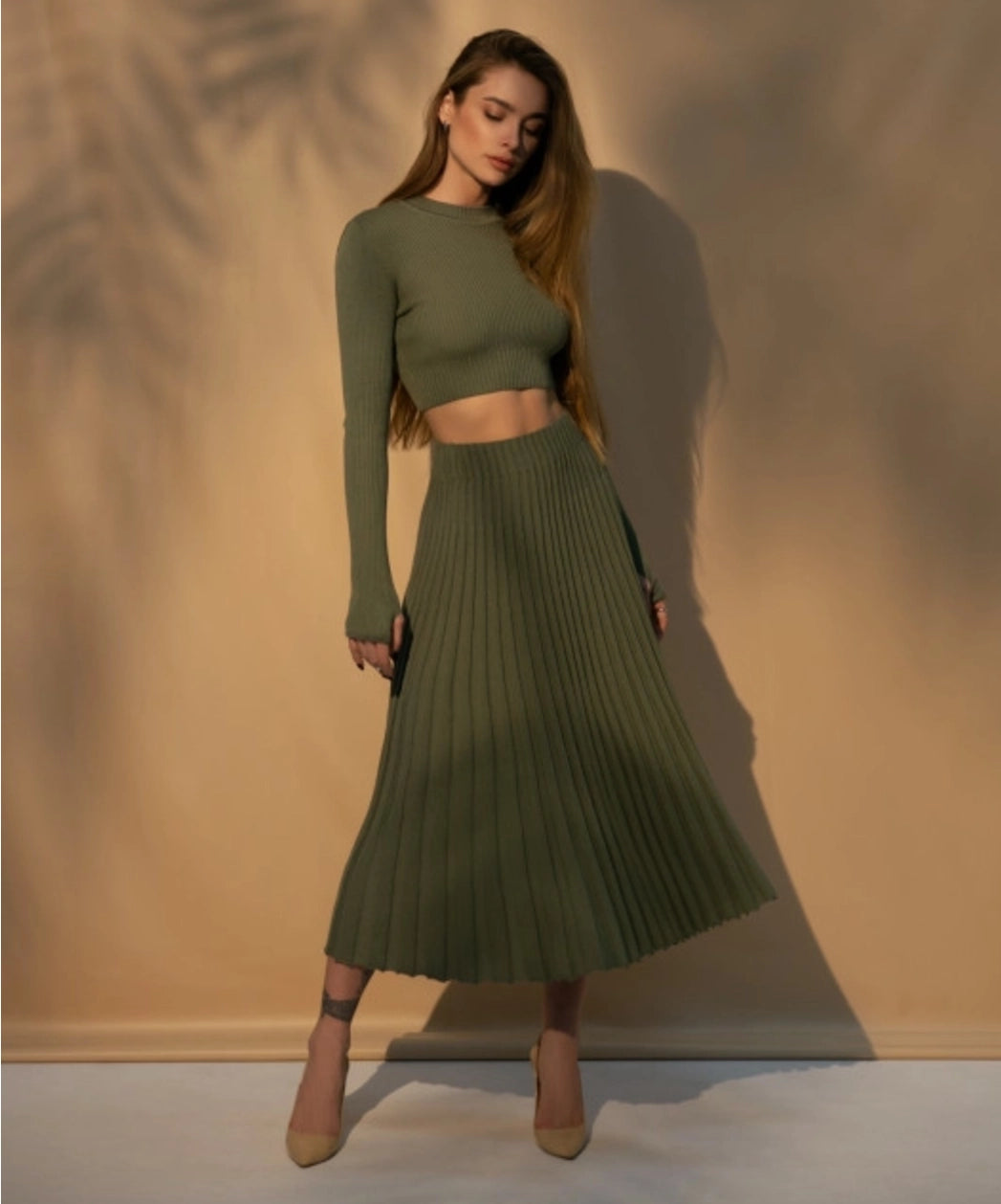 A pleated midi skirt featuring a wide belt at a high waist, meticulously crafted with natural cotton thread for a timeless and elegant look.